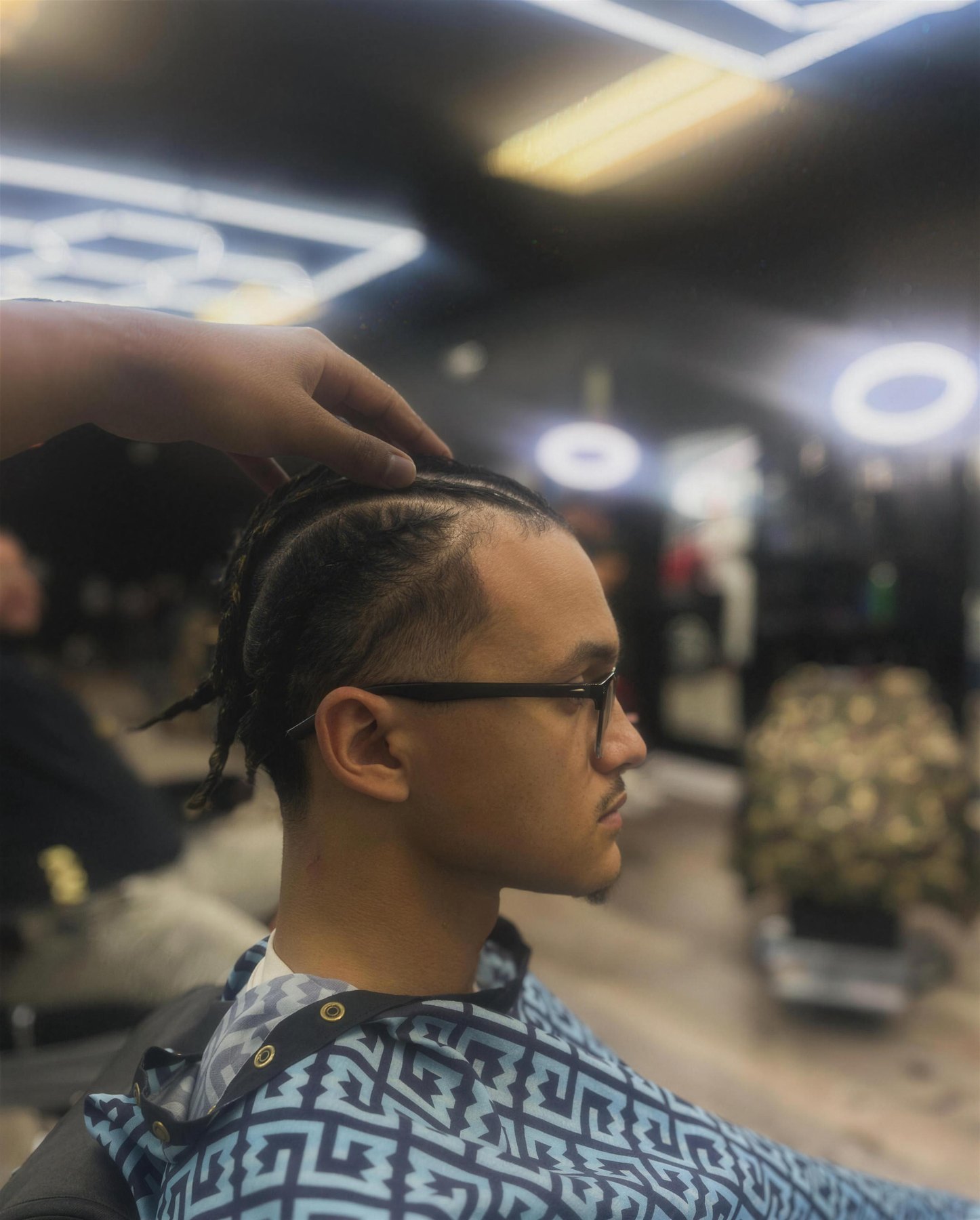 Real T-Low client getting braids finished, inside the real shop