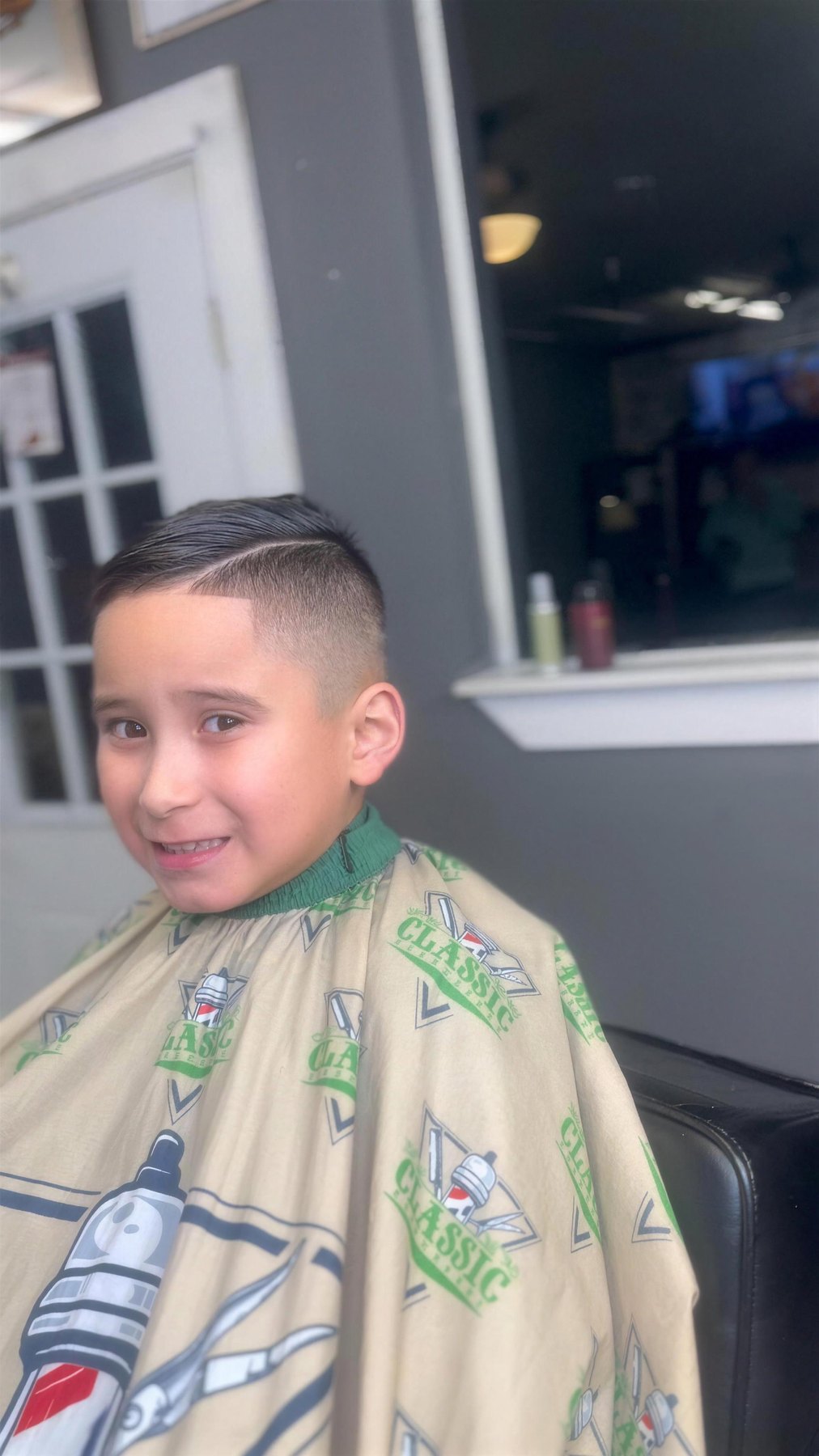 Real kid client with a fresh fade, smiling