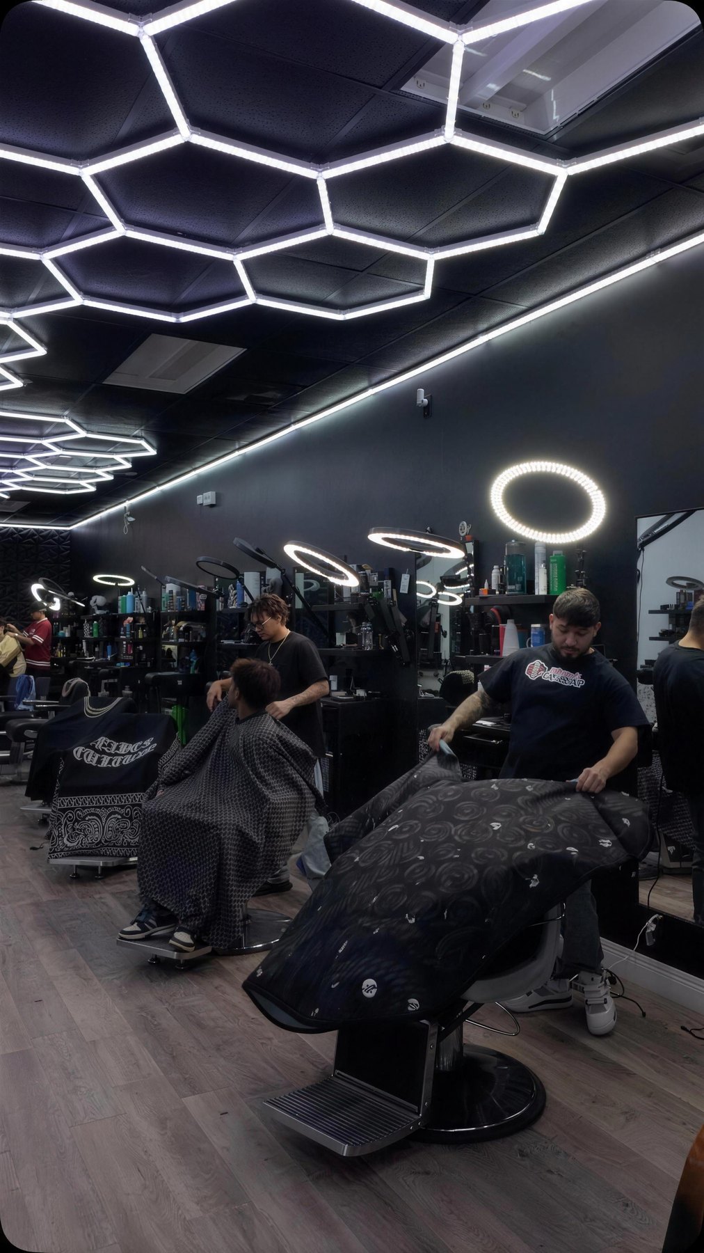 Real interior of Plugged In Barbershop 410 — wide floor shot, chairs, hexagon LED ceiling