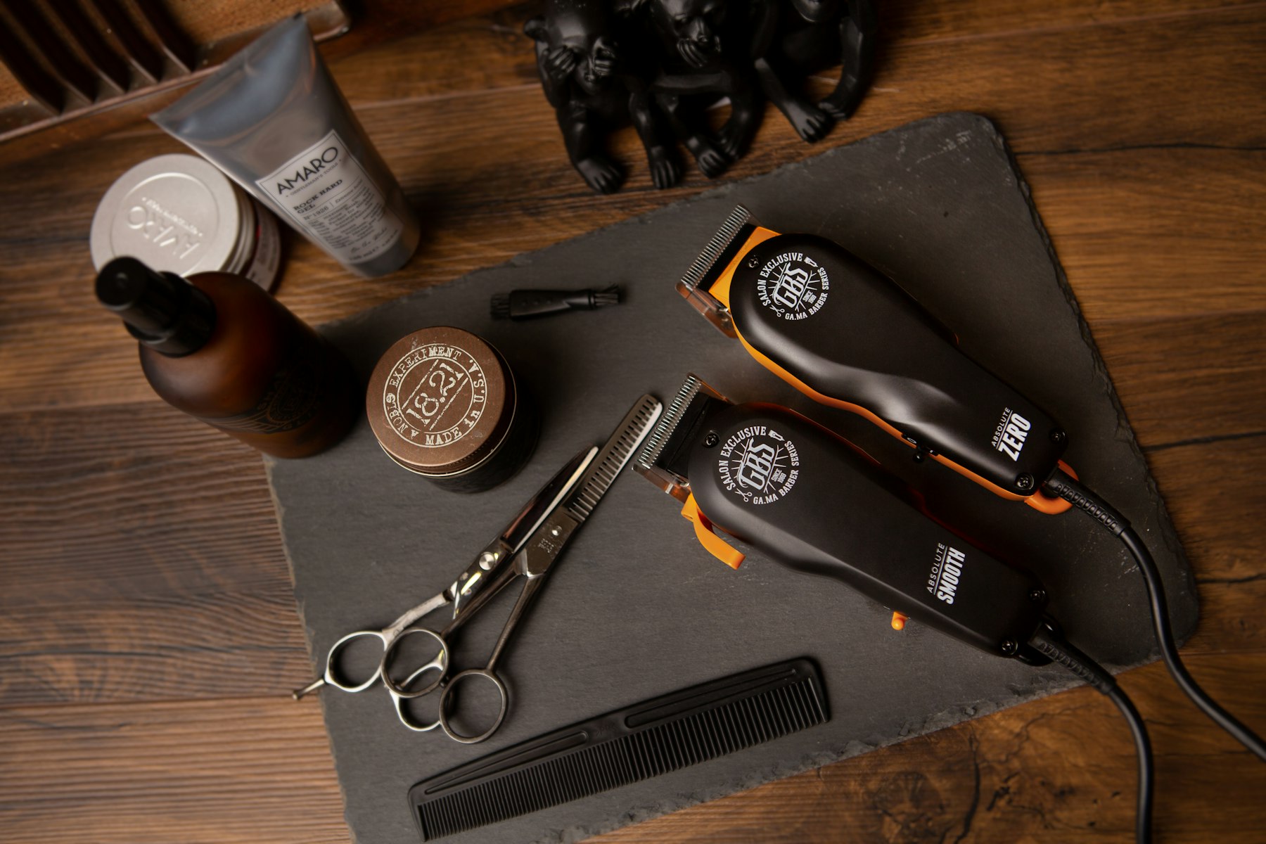 Clippers, scissors, and pomade laid out on a wood counter — reference photo